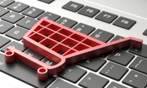 El volumen de un carro de compras sobre el teclado de un PC, simboliza un ecommerce